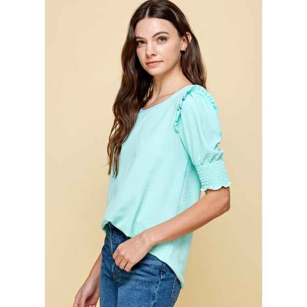 side view of mint colored shirt with ruffled and smocked sleeve