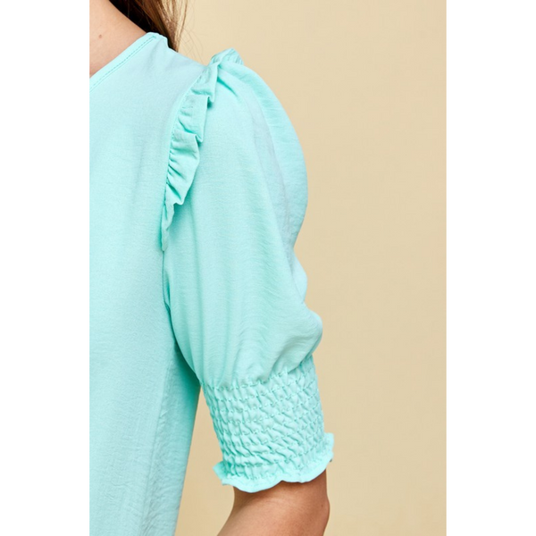 close up of sleeve for mint colored shirt with ruffled and smocked sleeve