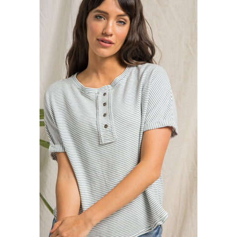 short sleeve cream top with dark teal stripes, buttons, and rolled up sleeves.