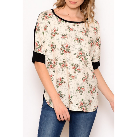 floral top with drop sleeves and black cuff on bottom of sleeves.