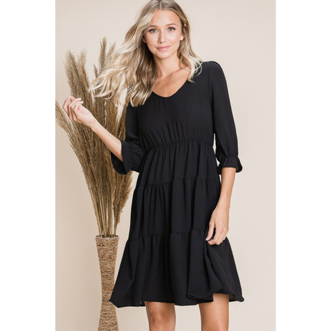 front view of tiered black dress with 3/4 length sleeves