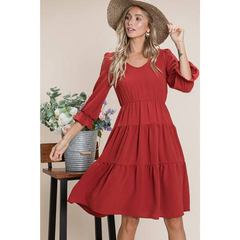 rust colored tiered dress with 3/4 length sleeves