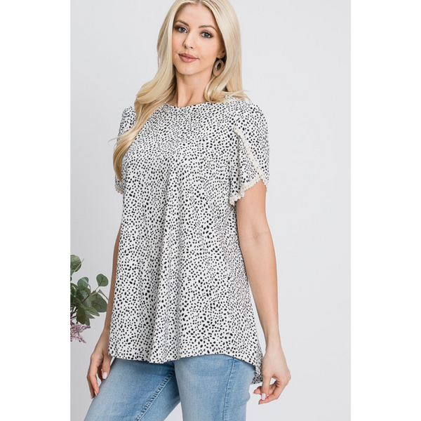 cream colored tulip sleeve top with black spotted pattern and lace trim